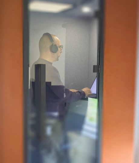 IT-expert van mad.IT aan het werk in een geluidsdichte focusruimte, gericht op softwaremonitoring en betrouwbare digitale ondersteuning op maat.